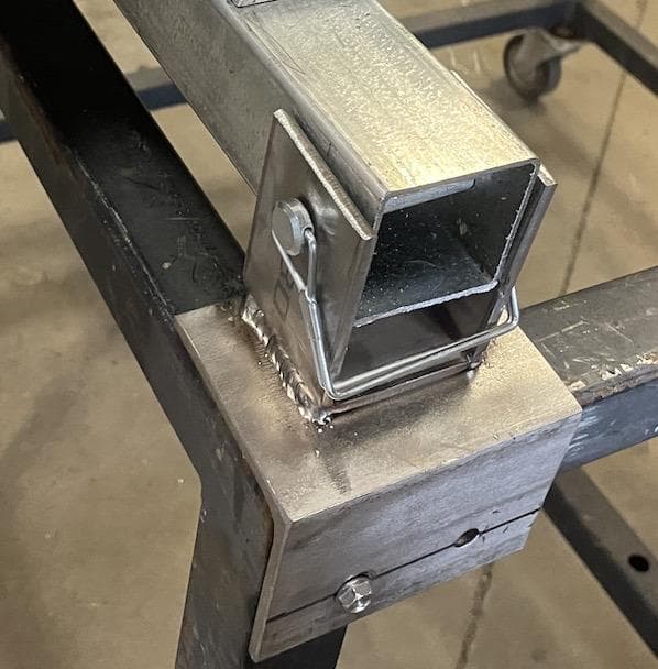 Galvanised support member seated in a welded bracket at a container's edge
